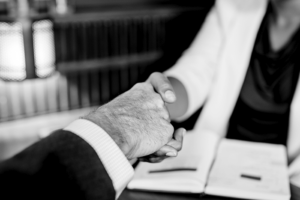 Close shot of two business professionals' shaking hands. Black and white photograph.
